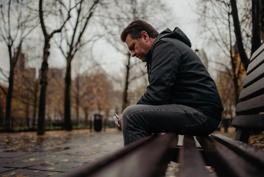 Депрессия Грустный мужчина сидит на лавочке